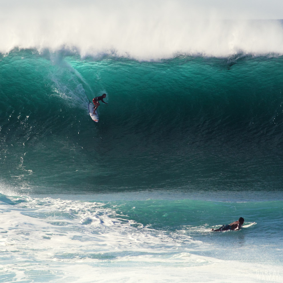 A surfer drops in on a huge wave at Pipeline on Oahu's North Shore