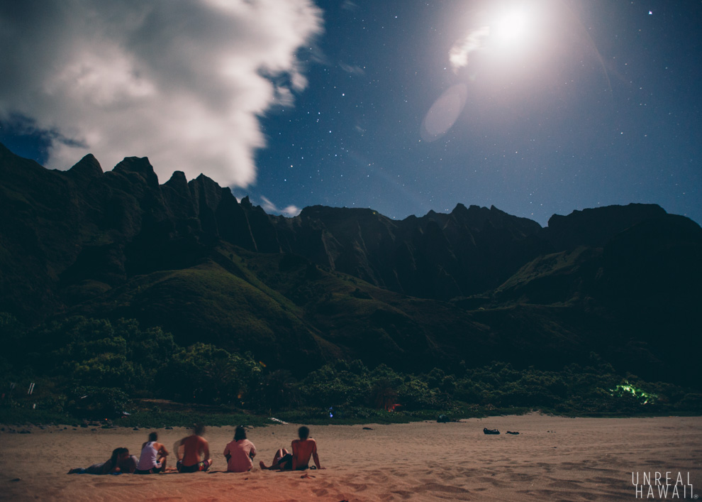 The moon shines over the mountain and beach at Kalalau, Kauai, Hawaii.